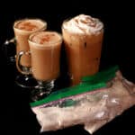 2 mugs of high protein gingerbread latte, a tall glass of protein powder iced gingerbread latte, and a few bags of the mix.