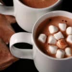 2 mugs of protein hot chocolate and several baggies of protein powder hot chocolate mix.