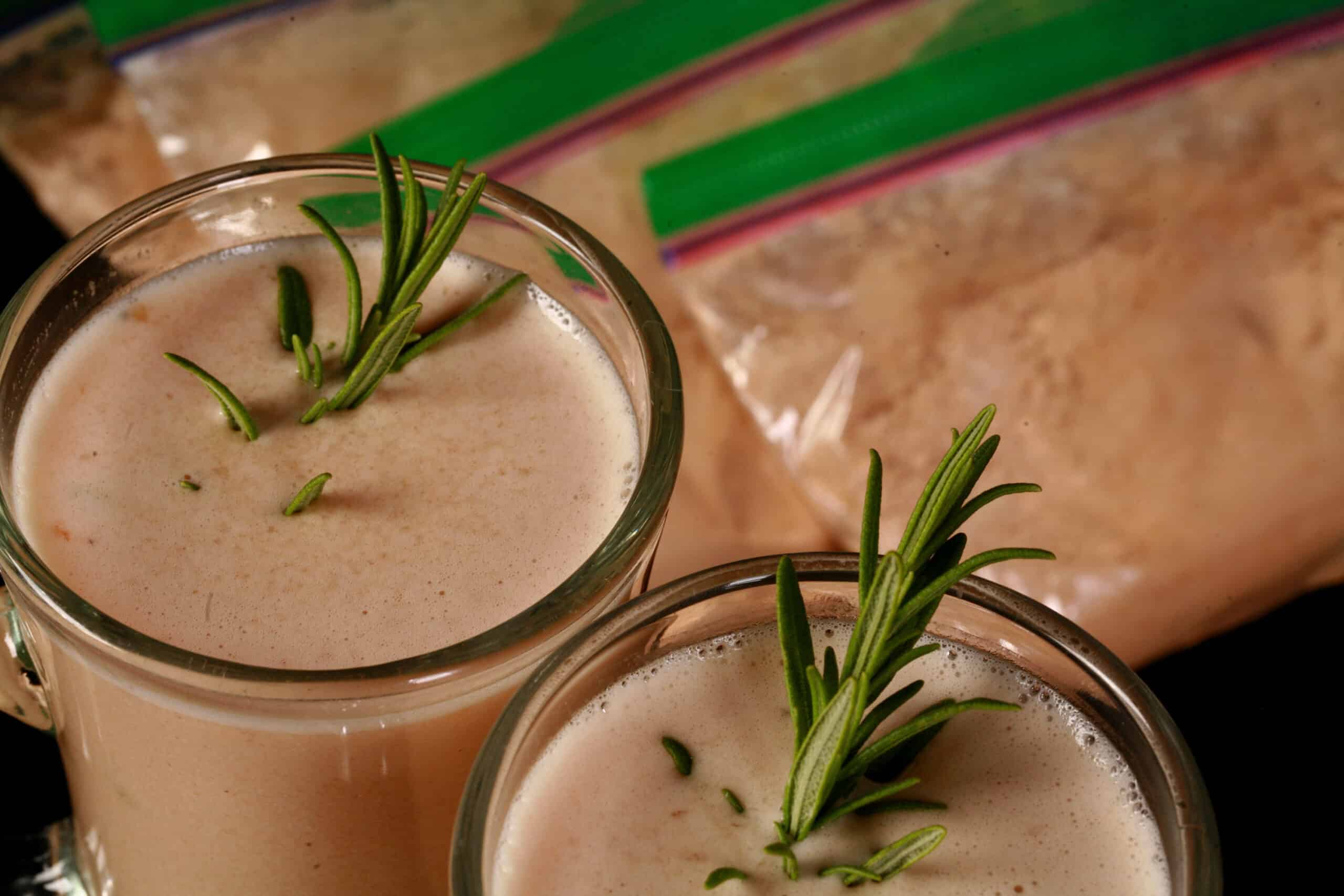 2 mugs of protein powder cream of chicken soup, with baggies of protein creamy chicken soup mix next to them.