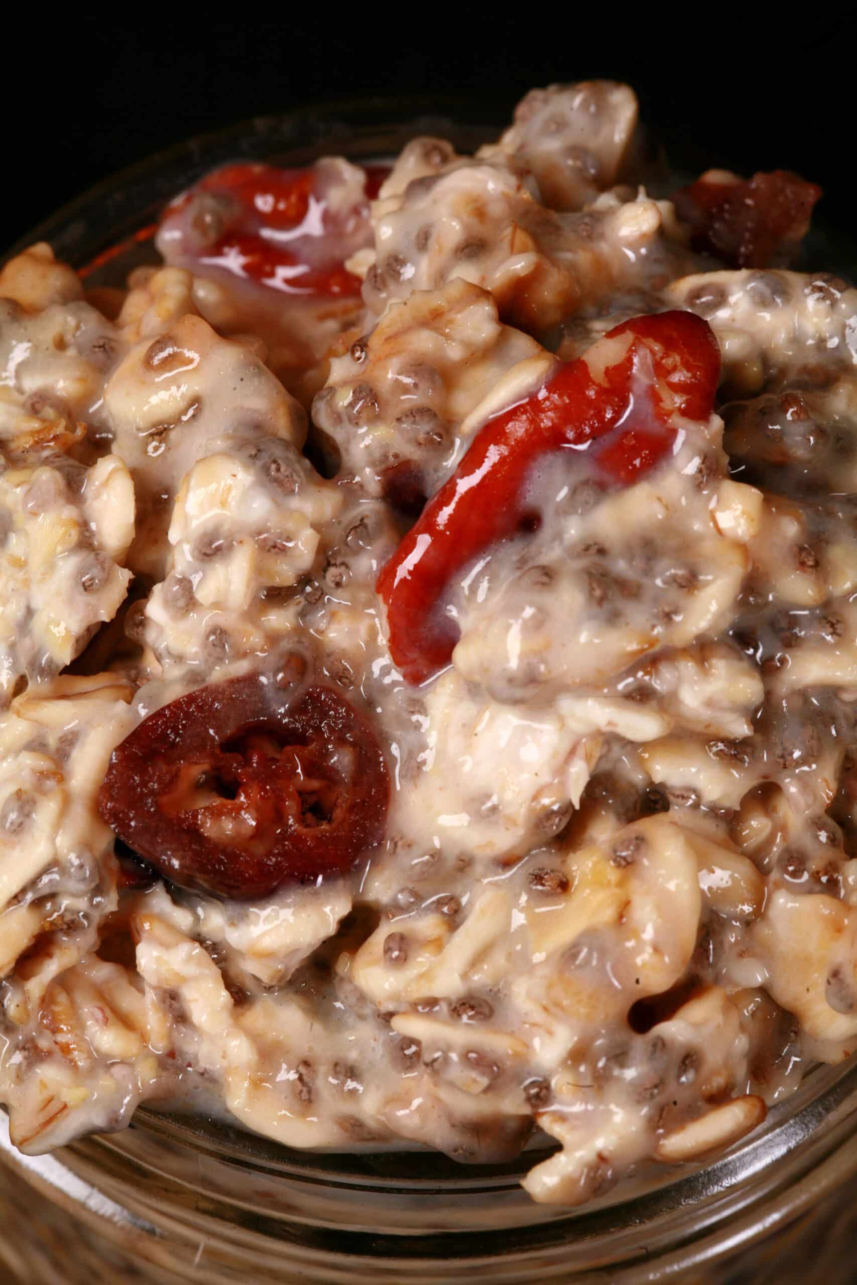 A jar of cranberry orange overnight oats, with dried cranberries and walnuts showing.