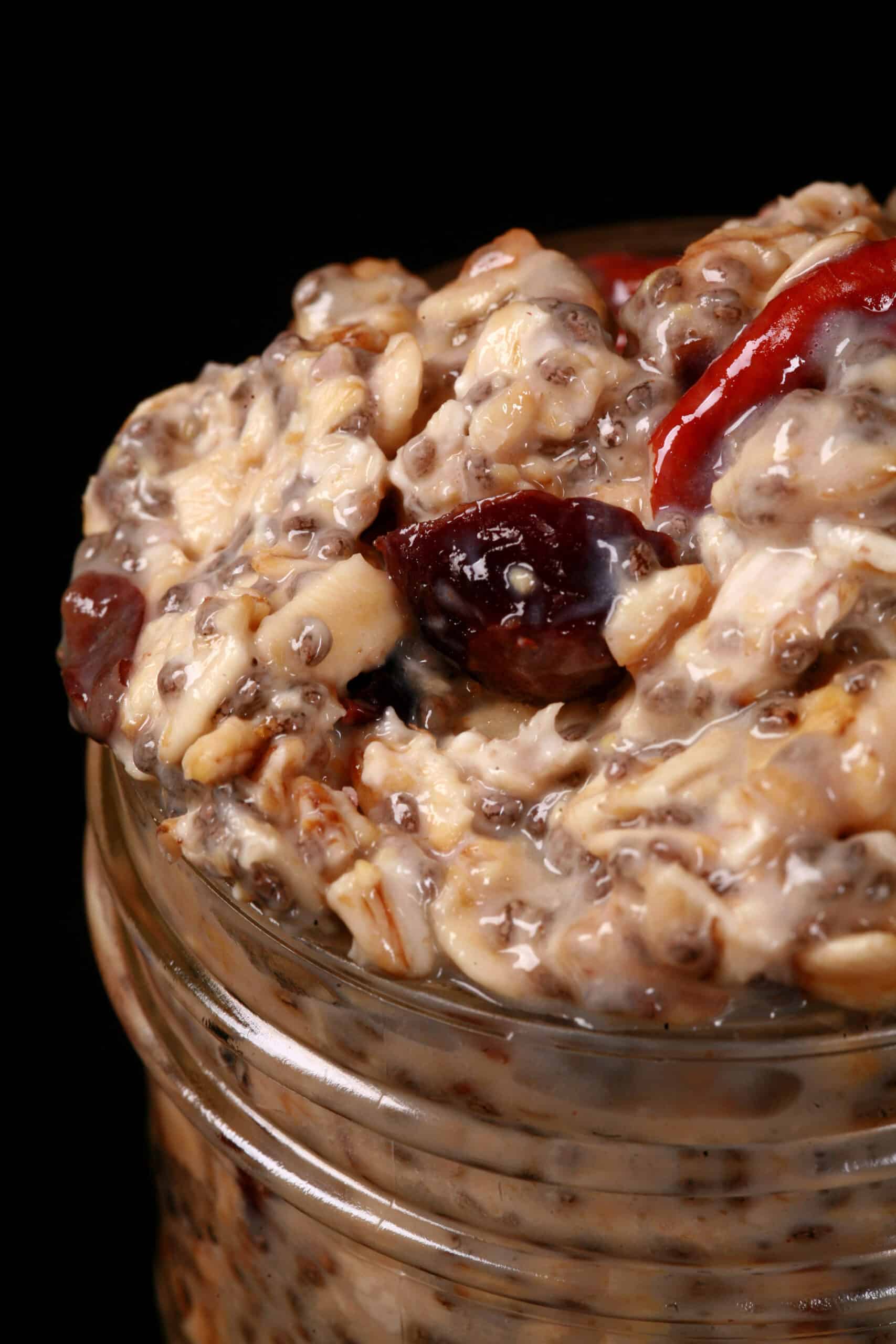 A jar of cranberry orange overnight oats, with dried cranberries and walnuts showing.