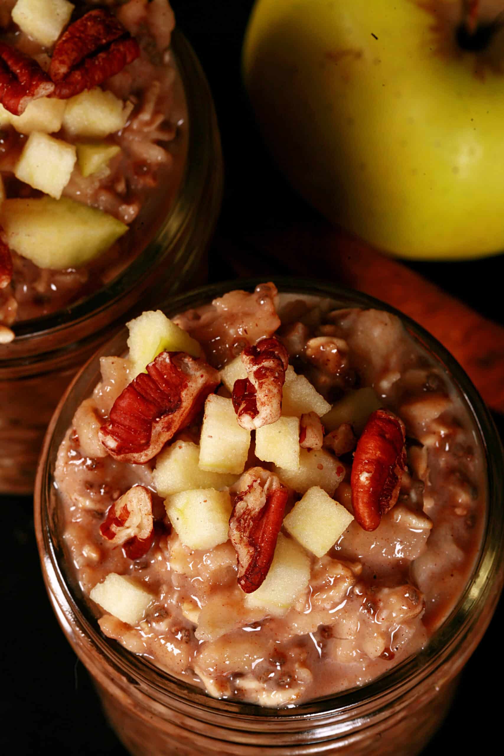 2 jars of high protein apple cinnamon overnight oats, topped with chopped apples and pecans.