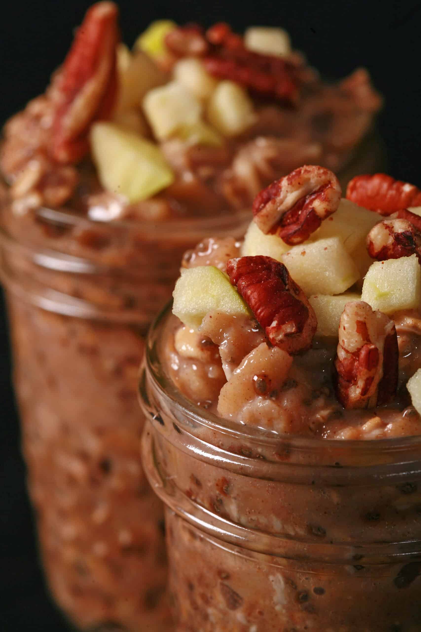 2 jars of high protein apple cinnamon overnight oats, topped with chopped apples and pecans.