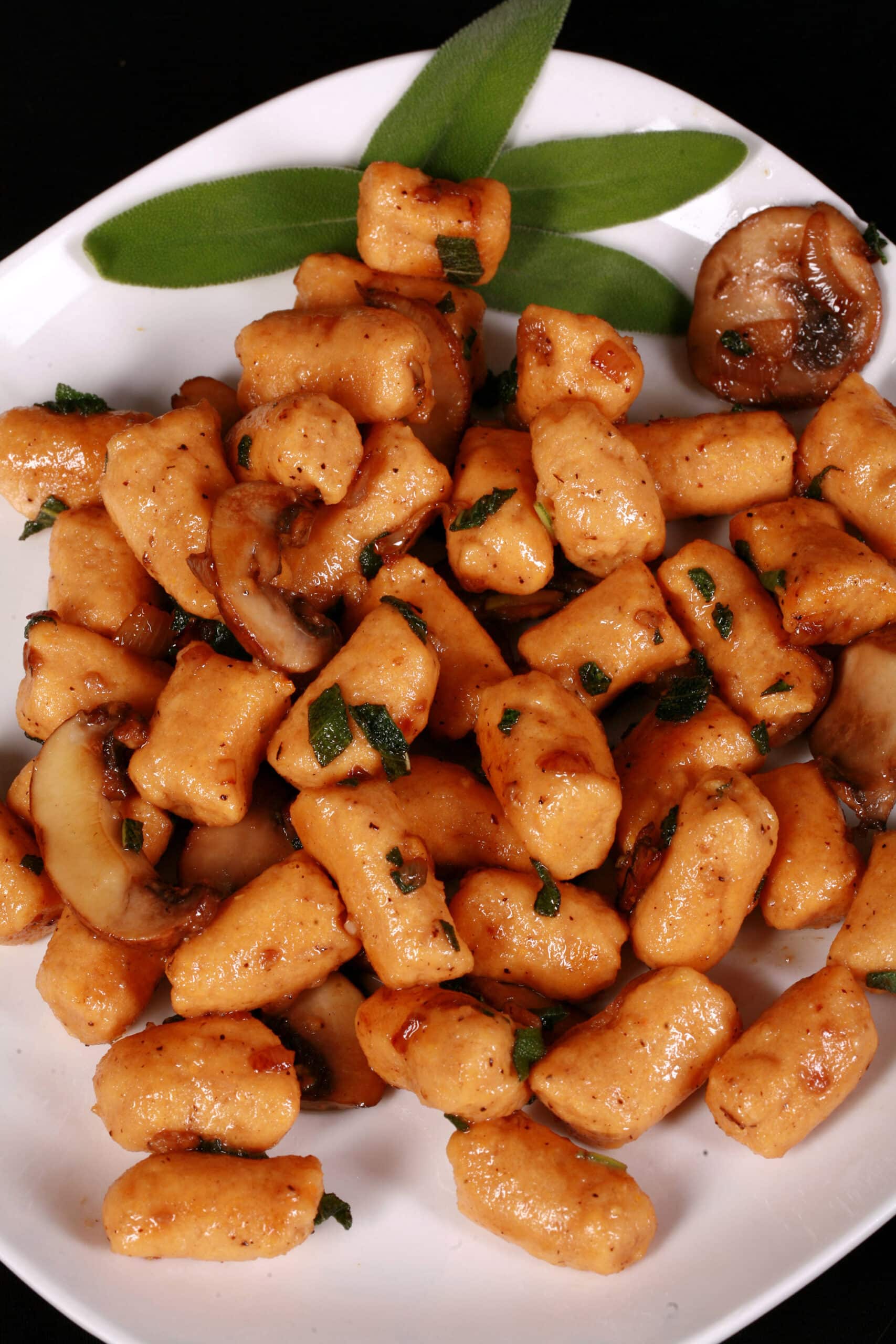 A plate of high protein sweet potato gnocchi with sauteed mushrooms and sage.