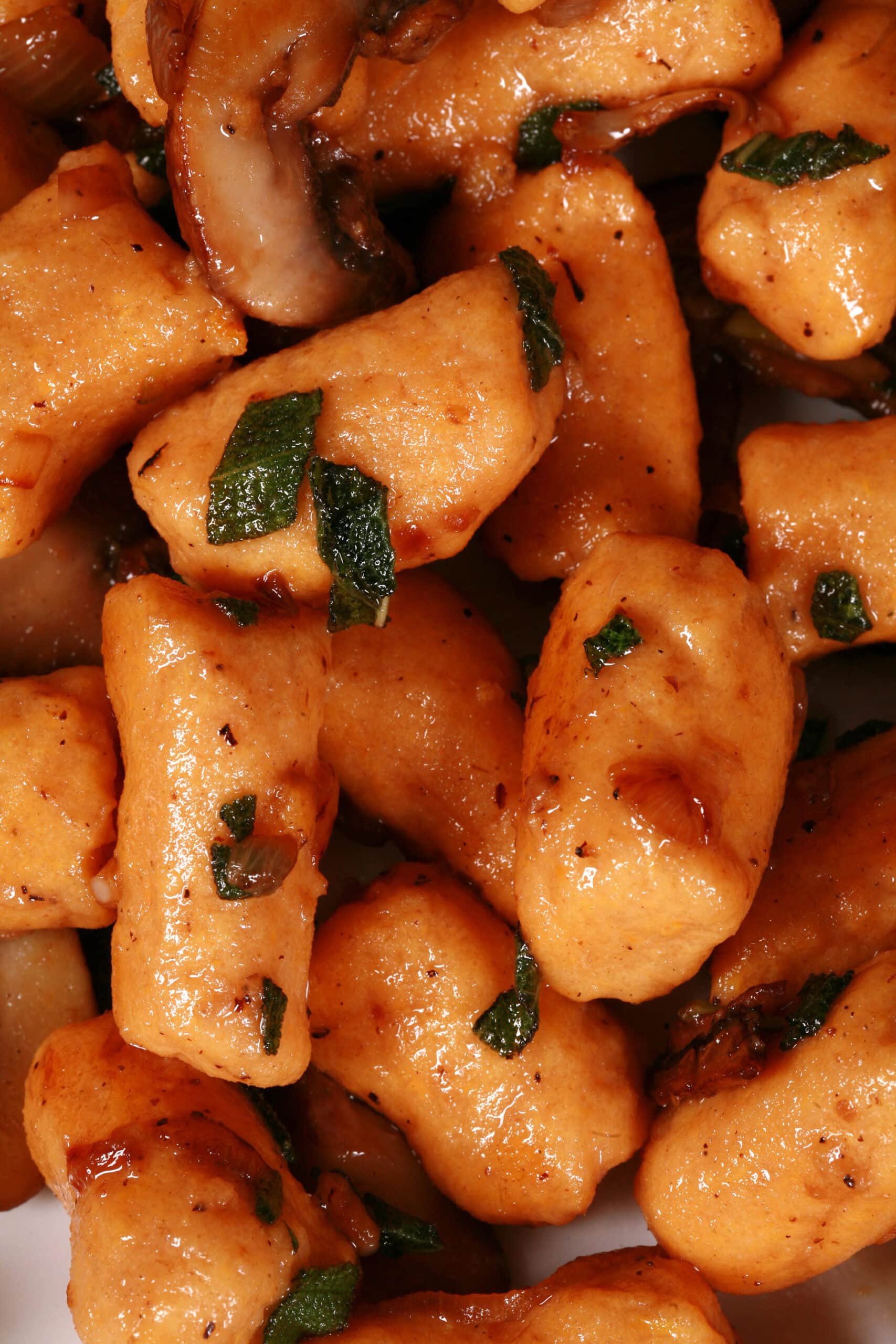 A plate of protein powder sweet potato gnocchi with sauteed mushrooms and sage.