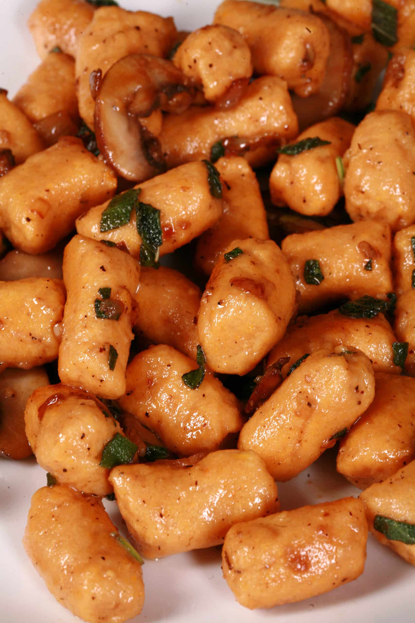 A plate of protein powder sweet potato gnocchi with sauteed mushrooms and sage.