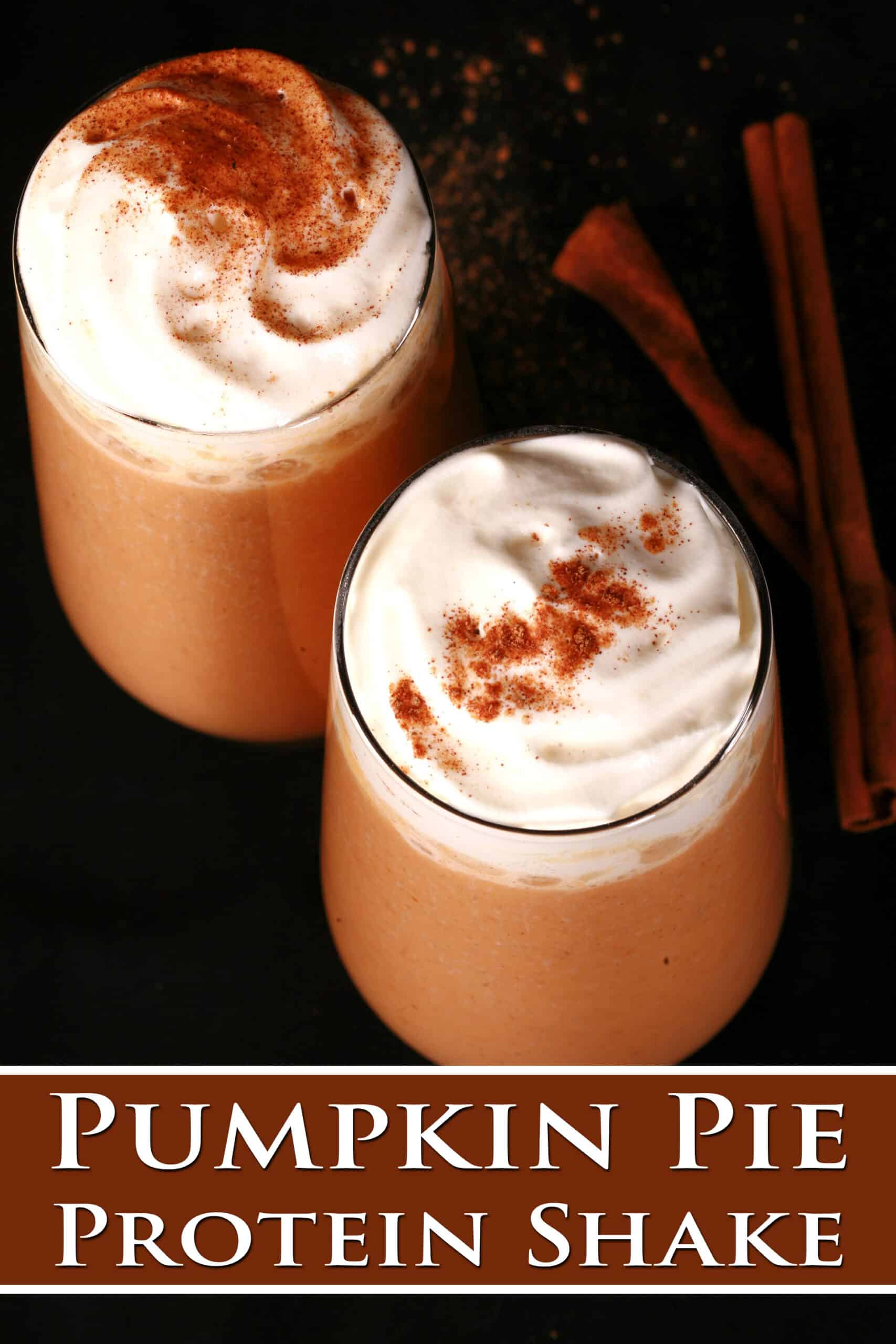 2 pumpkin pie protein smoothies in tall glasses, topped with whipped cream and pumpkin spice. Overlaid text says pumpkin pie protein shake.