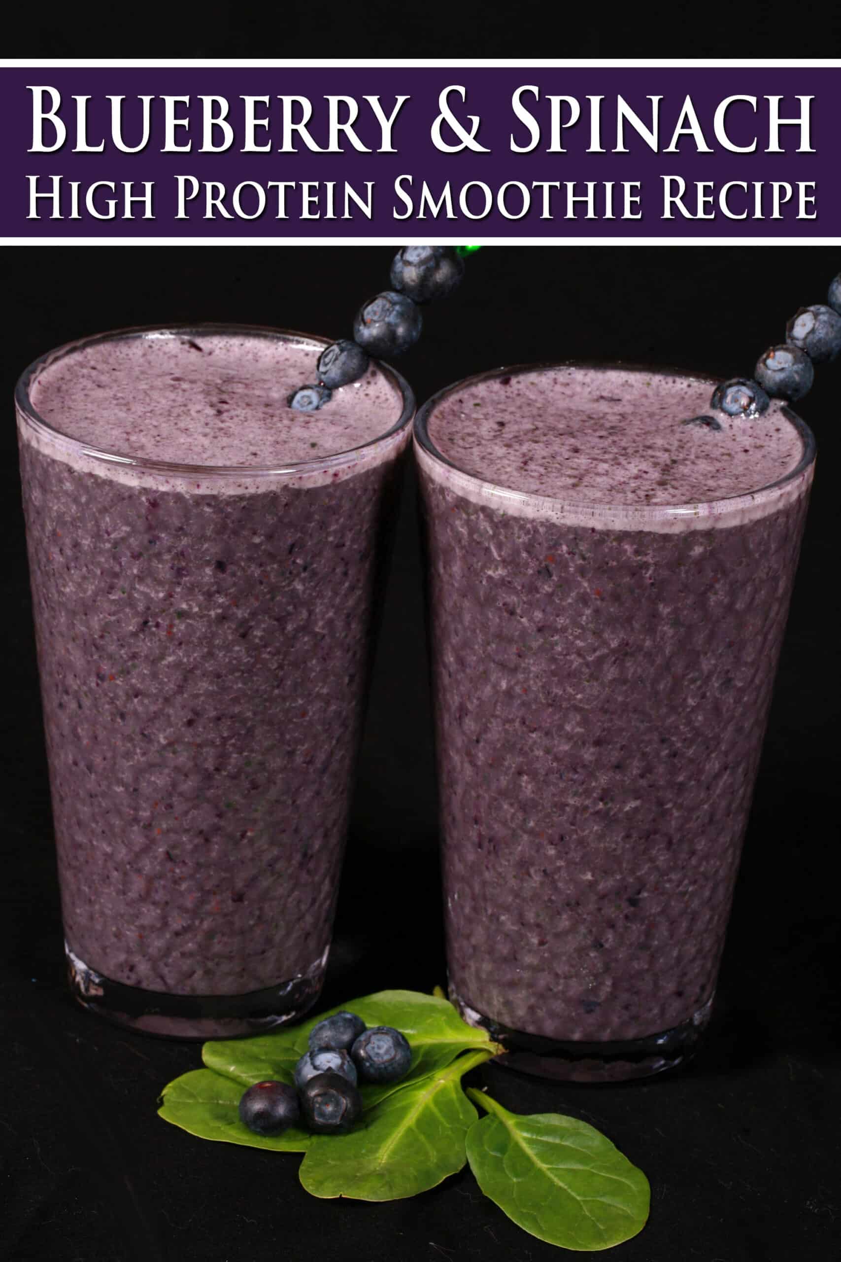 2 tall glasses of high protein blueberry spinach smoothies, garnished with fresh blueberries and baby spinach. Overlaid text says blueberry and spinach high protein smoothie recipe.