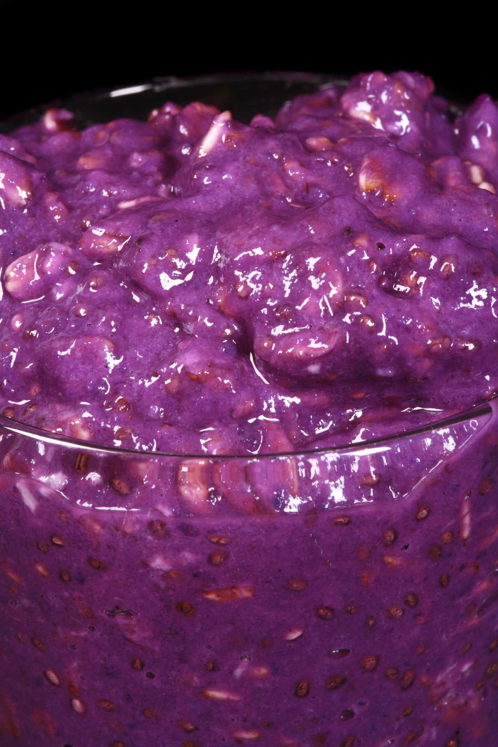 A mason jar of bright purple high protein Ube Overnight Oatmeal.