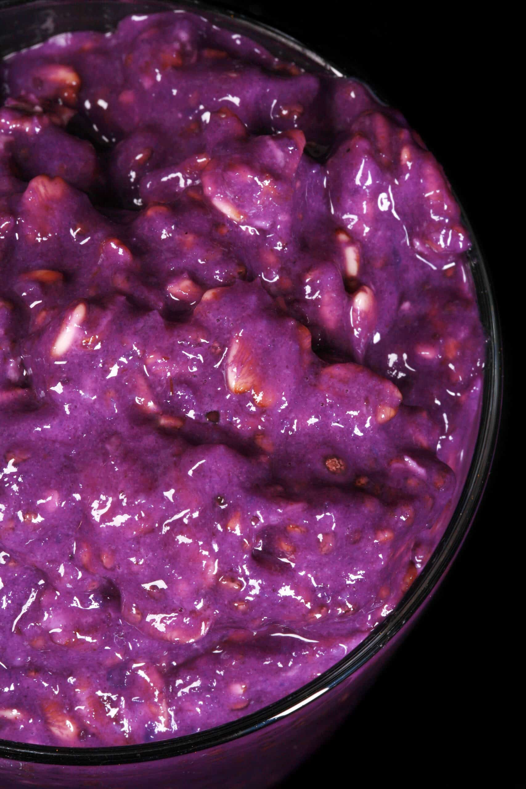 A mason jar of bright purple high protein Ube Overnight Oats.
