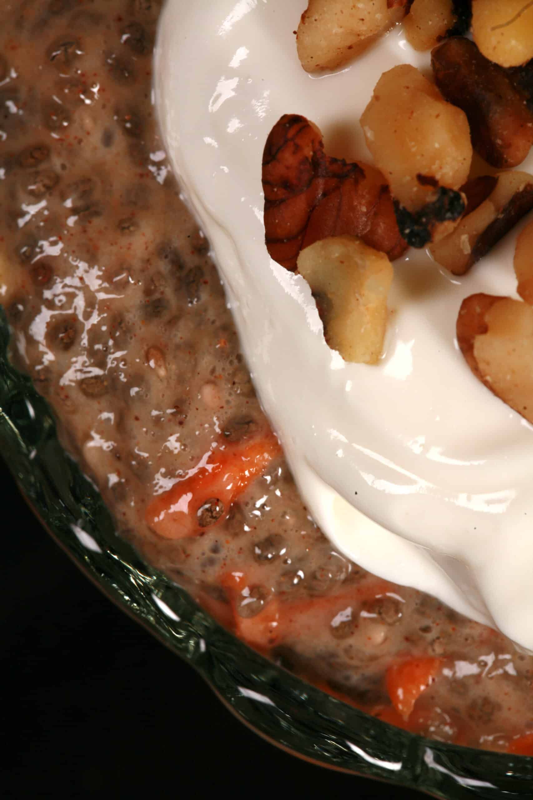 a dessert cup of carrot cake high protein chia pudding, topped with cream cheese Greek yogurt topping and chopped walnuts.