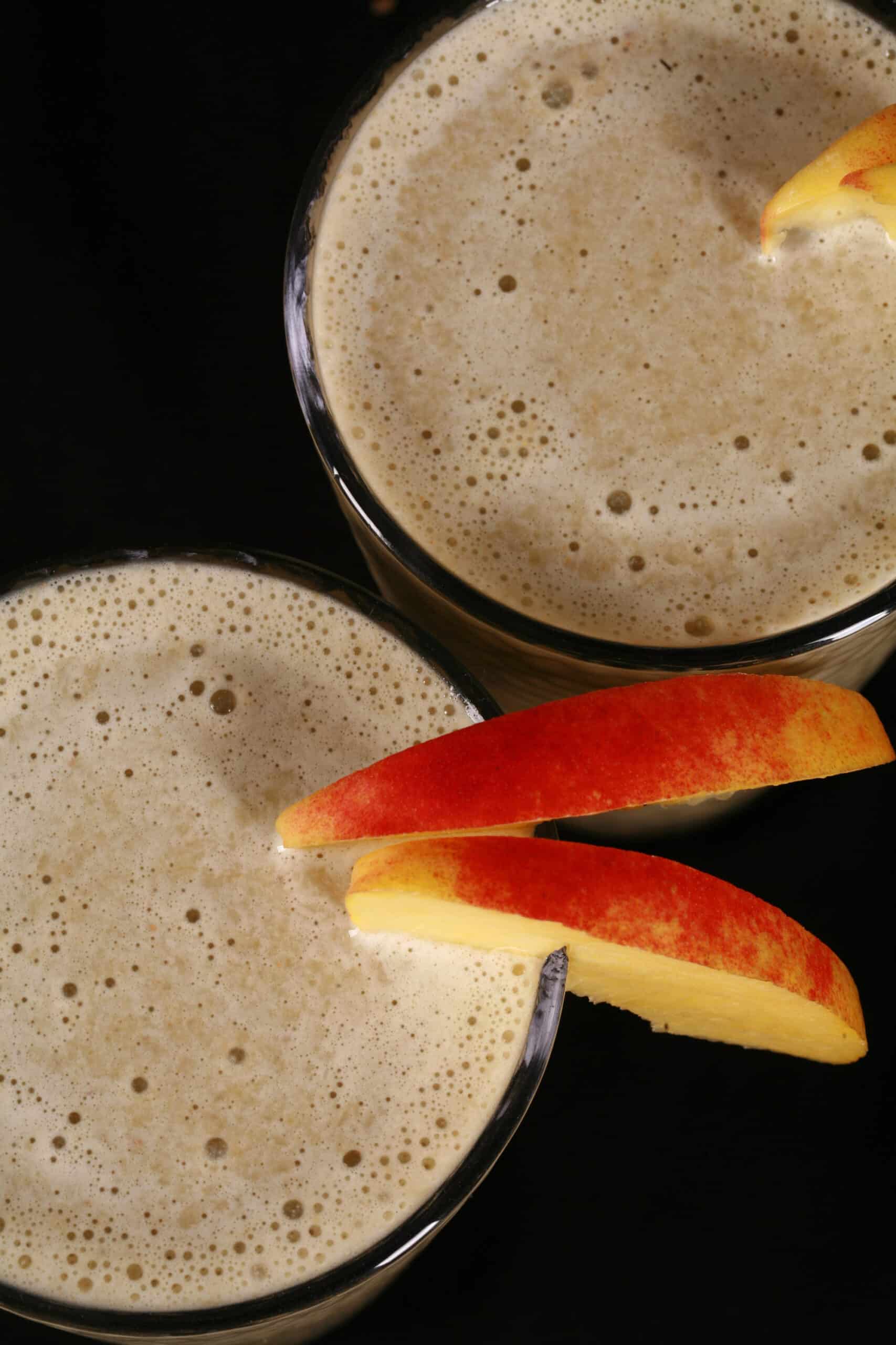 2 ginger peach matcha protein smoothies, with fresh peaches and ginger root.