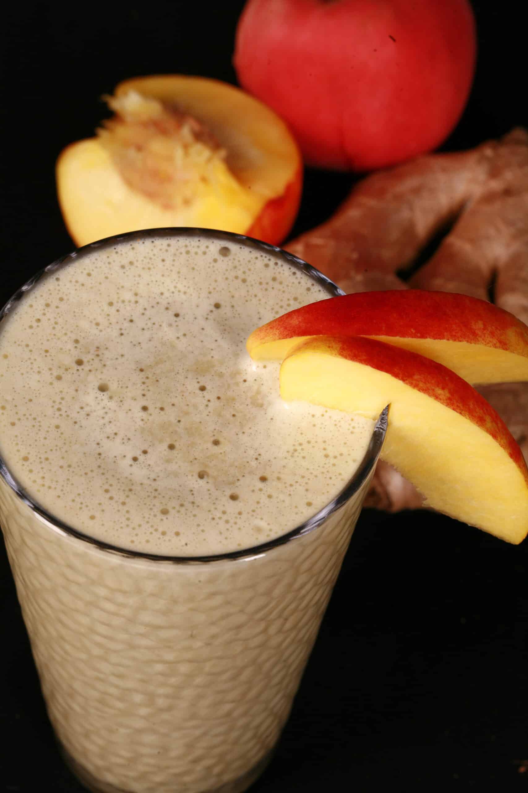 2 ginger peach matcha protein smoothies, with fresh peaches and ginger root.